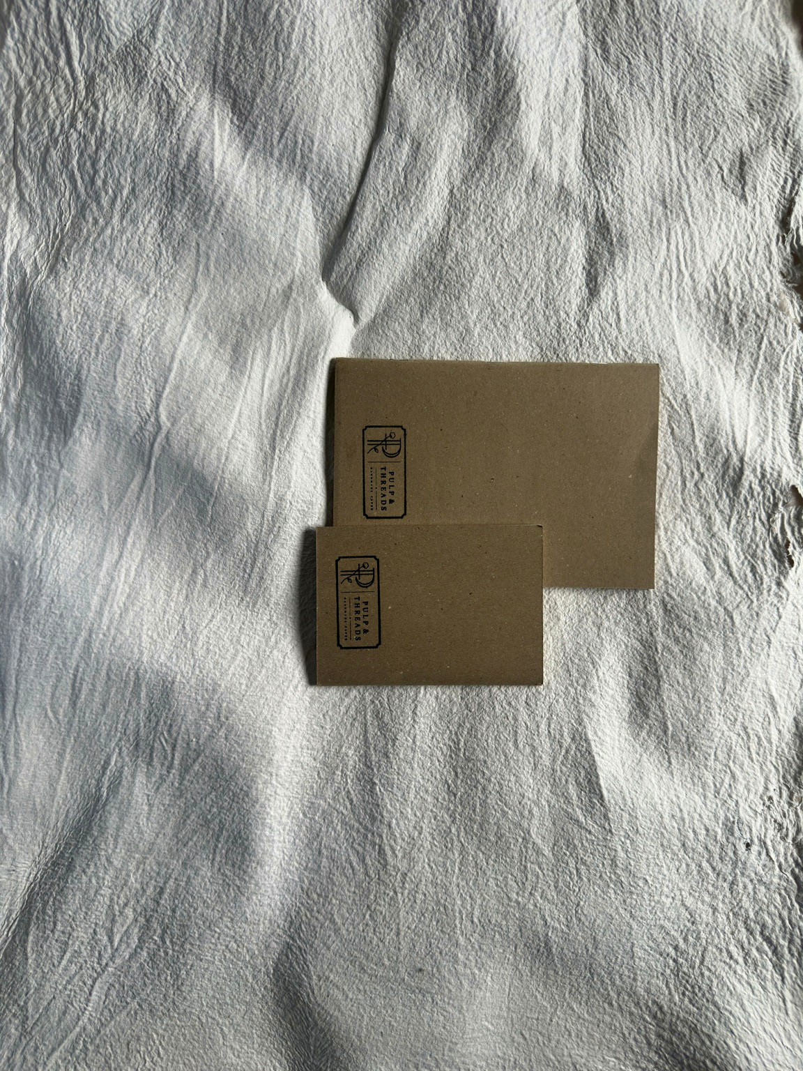 A small spiral-bound notebook opened to show its handmade paper pages